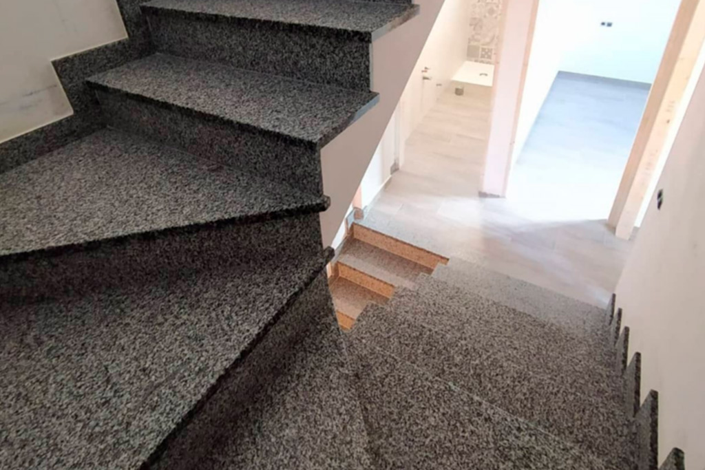 Fotografía de unas escaleras de una casa. Los peldaños son de mármol.